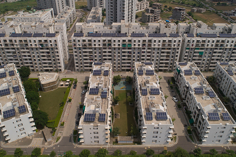 Aerial view of township rooftops fitted with solar panels